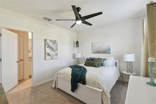 bedroom with visible vents, light carpet, ensuite bath, baseboards, and ceiling fan