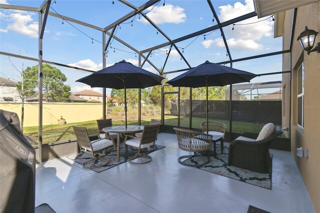 view of patio featuring glass enclosure and outdoor dining space