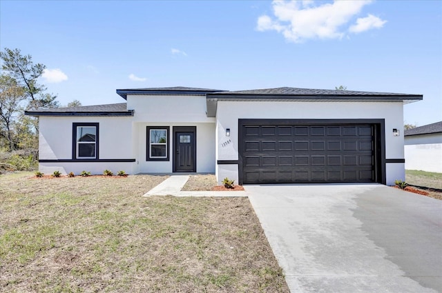 view of front facade with stucco siding, driveway, a front lawn, and a garage