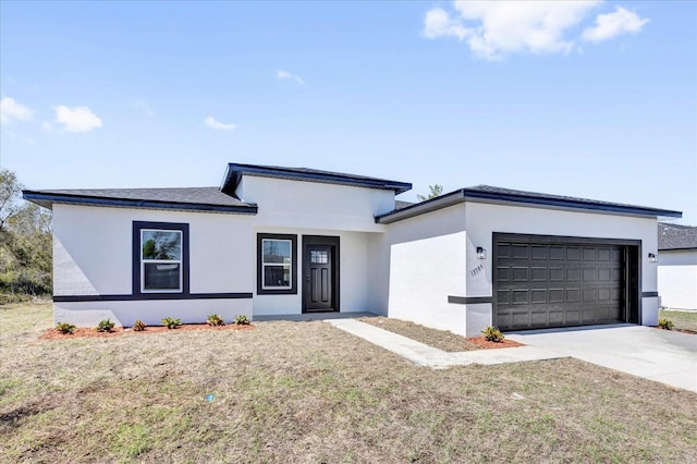 view of front of house with a garage, concrete driveway, and stucco siding