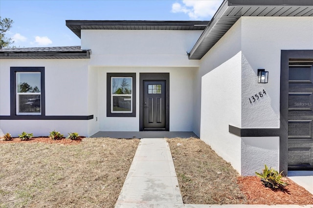 doorway to property featuring stucco siding