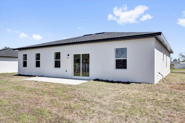 back of property featuring a patio, a lawn, and stucco siding