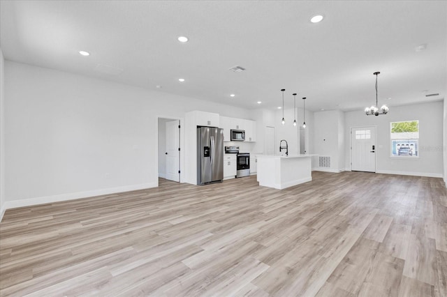 unfurnished living room with recessed lighting, light wood-type flooring, a chandelier, and a sink