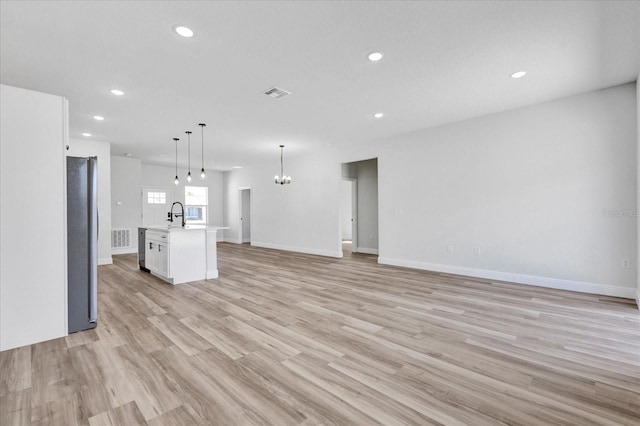 kitchen with white cabinetry, an inviting chandelier, open floor plan, and visible vents