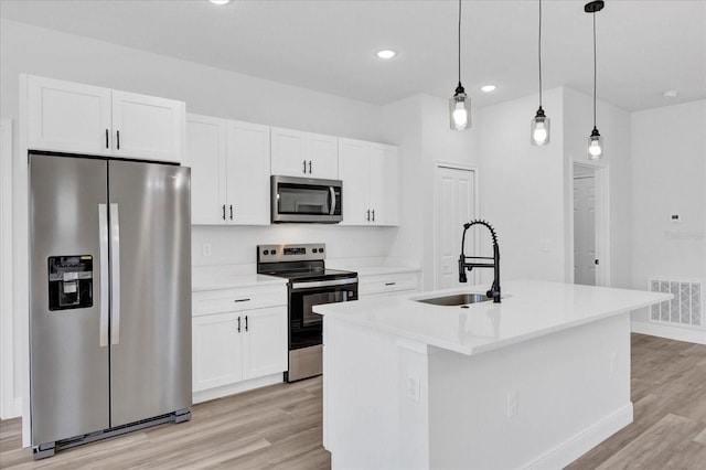 kitchen with visible vents, a sink, white cabinetry, appliances with stainless steel finishes, and light wood finished floors