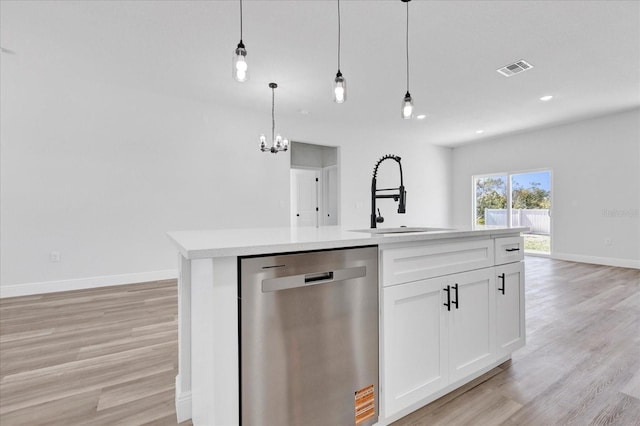 kitchen with visible vents, light wood-style flooring, a sink, stainless steel dishwasher, and light countertops