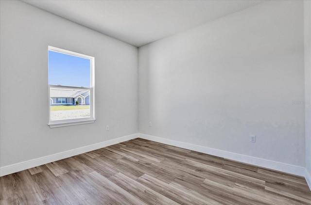 empty room featuring baseboards and wood finished floors