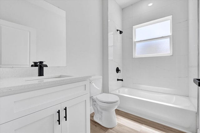 full bathroom featuring bathtub / shower combination, toilet, wood finished floors, and vanity