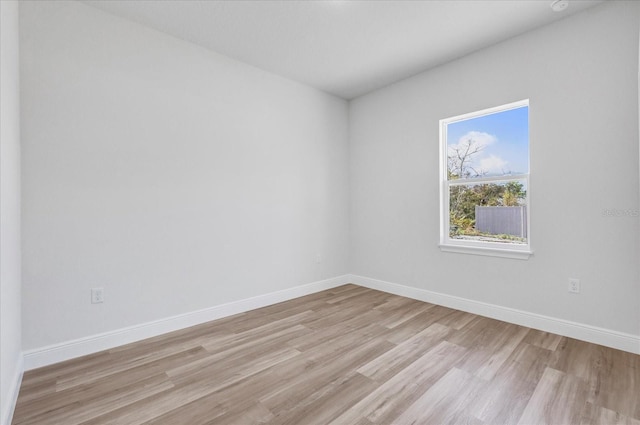 unfurnished room featuring baseboards and light wood finished floors