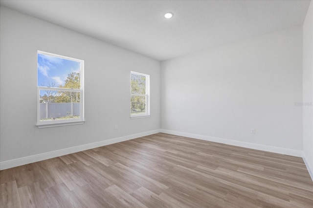 empty room featuring recessed lighting, light wood-style floors, and baseboards