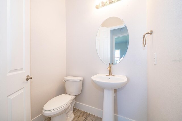 2400 Symphony Cir, Saint Cloud, FL 34771 - bathroom with baseboards, toilet, and wood finished floors