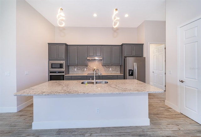 2400 Symphony Cir, Saint Cloud, FL 34771 - kitchen with baseboards, gray cabinetry, under cabinet range hood, stainless steel appliances, and a sink