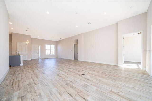 2400 Symphony Cir, Saint Cloud, FL 34771 - unfurnished living room featuring a sink, baseboards, and light wood-style floors