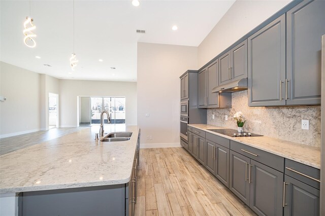 2400 Symphony Cir, Saint Cloud, FL 34771 - kitchen featuring black electric cooktop, gray cabinetry, under cabinet range hood, stainless steel oven, and a sink
