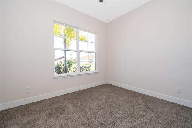 2400 Symphony Cir, Saint Cloud, FL 34771 - empty room with dark carpet, baseboards, and vaulted ceiling