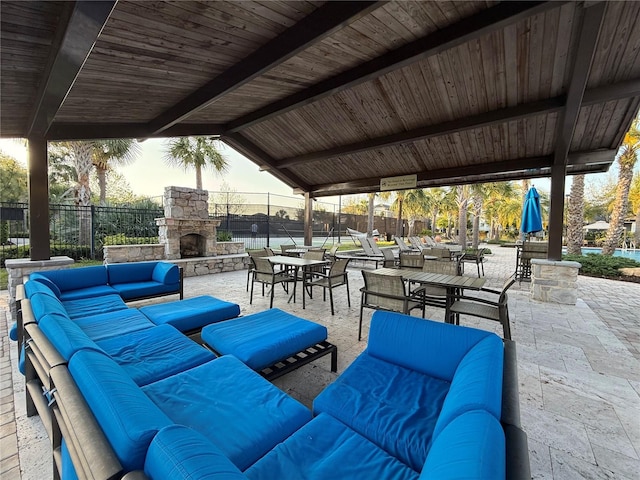 view of patio / terrace featuring fence and an outdoor living space with a fireplace