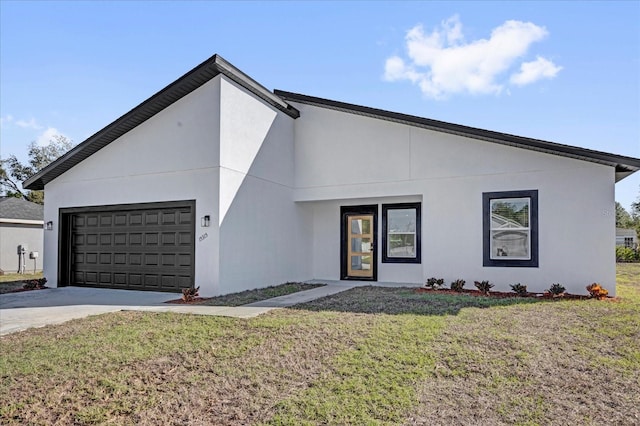 view of front of house with a garage, a front yard, driveway, and stucco siding