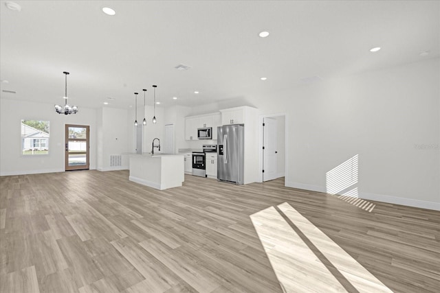 unfurnished living room with recessed lighting, light wood-type flooring, a chandelier, and a sink