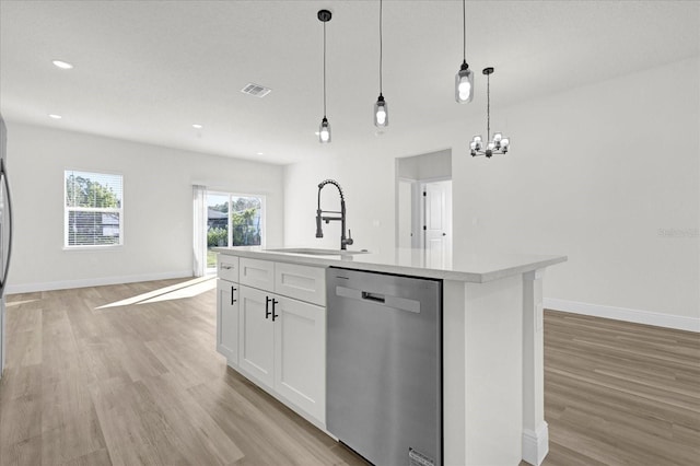 kitchen featuring visible vents, dishwasher, light countertops, light wood-style flooring, and a sink