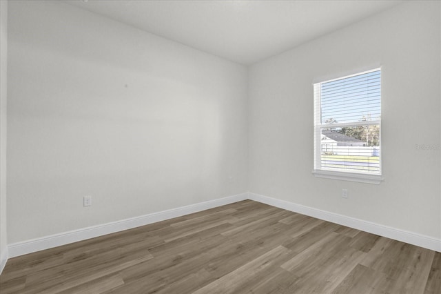 empty room with wood finished floors and baseboards