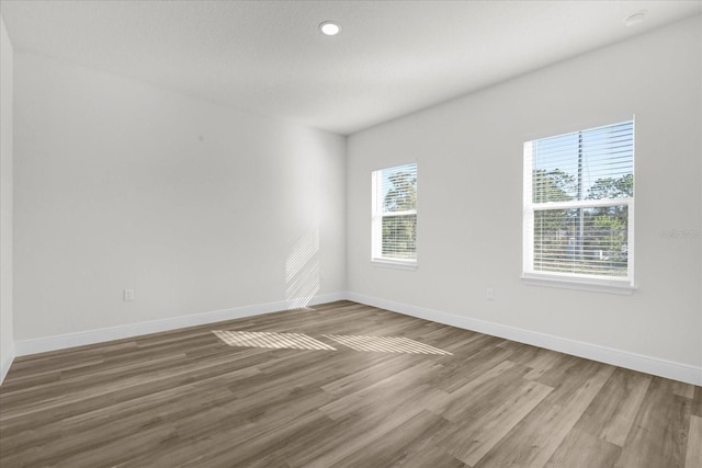 unfurnished room with baseboards and wood finished floors