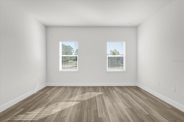 empty room featuring baseboards and wood finished floors