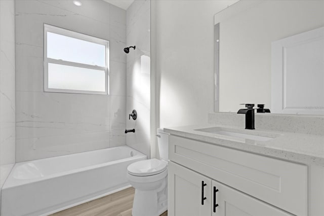 bathroom featuring shower / washtub combination, toilet, vanity, and wood finished floors