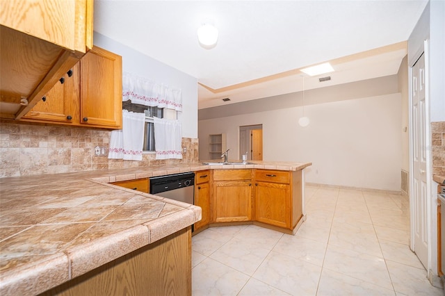 kitchen with a sink, decorative light fixtures, tasteful backsplash, stainless steel dishwasher, and a peninsula