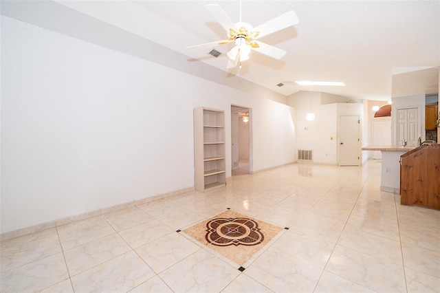 empty room featuring lofted ceiling, a ceiling fan, and visible vents