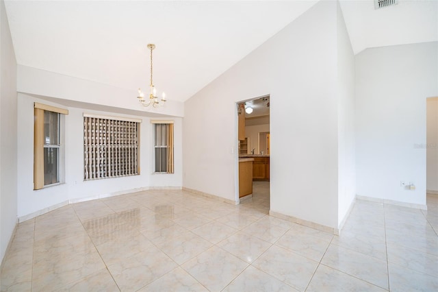 empty room featuring visible vents, baseboards, high vaulted ceiling, and a chandelier