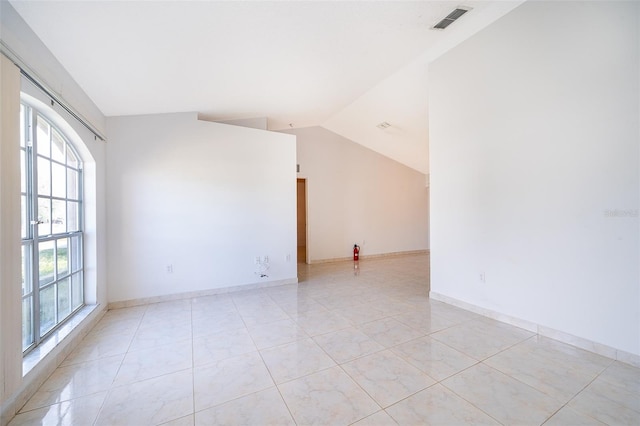 unfurnished room featuring light tile patterned floors, visible vents, baseboards, and vaulted ceiling