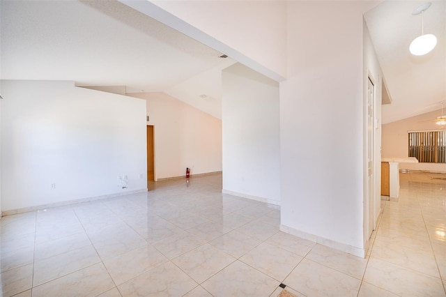 unfurnished room with baseboards, ceiling fan, and vaulted ceiling