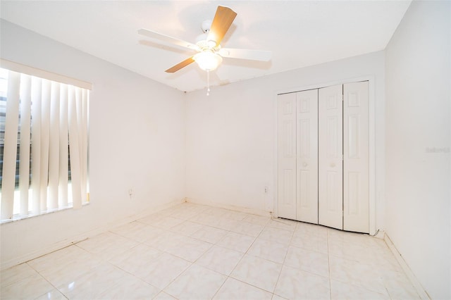 spare room with baseboards and ceiling fan