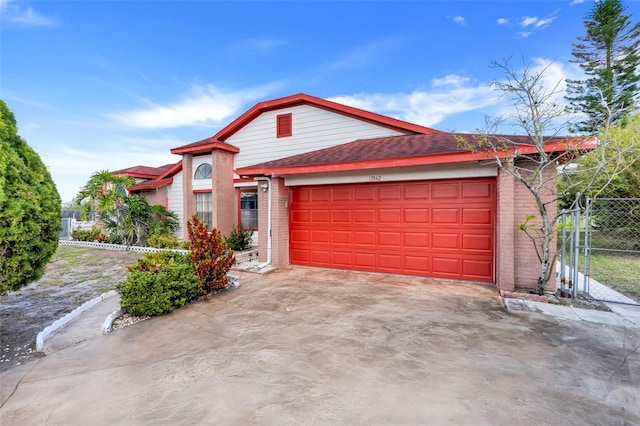 13542 Texas Woods Cir, Orlando, FL 32824 - view of front of property featuring fence, driveway, roof with shingles, a garage, and brick siding