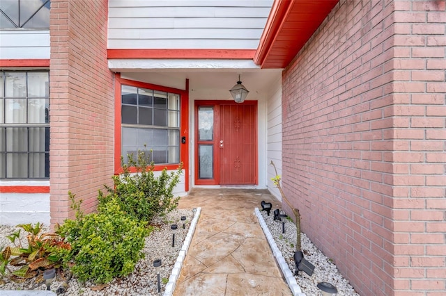 doorway to property featuring brick siding