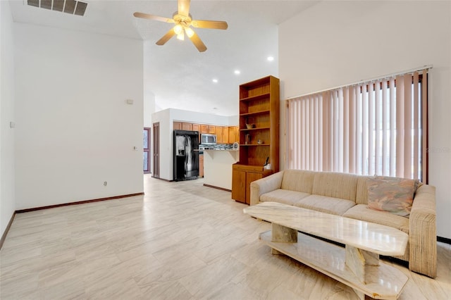 living area featuring baseboards, visible vents, a high ceiling, recessed lighting, and ceiling fan