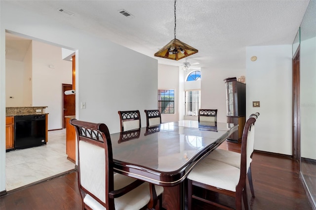 dining area with visible vents, baseboards, ceiling fan, light wood-style flooring, and a textured ceiling