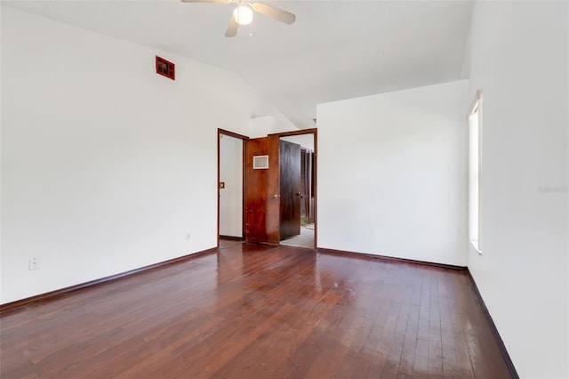 spare room featuring visible vents, a ceiling fan, hardwood / wood-style floors, baseboards, and vaulted ceiling