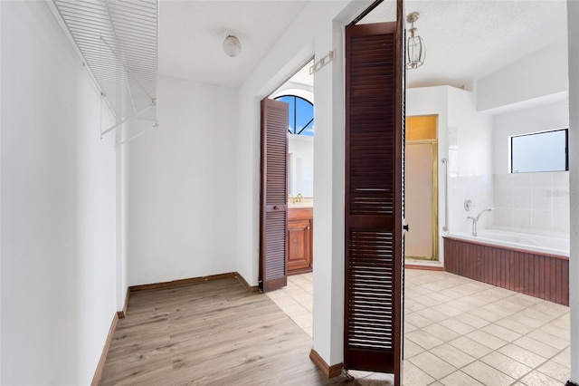 hall featuring light wood finished floors and baseboards