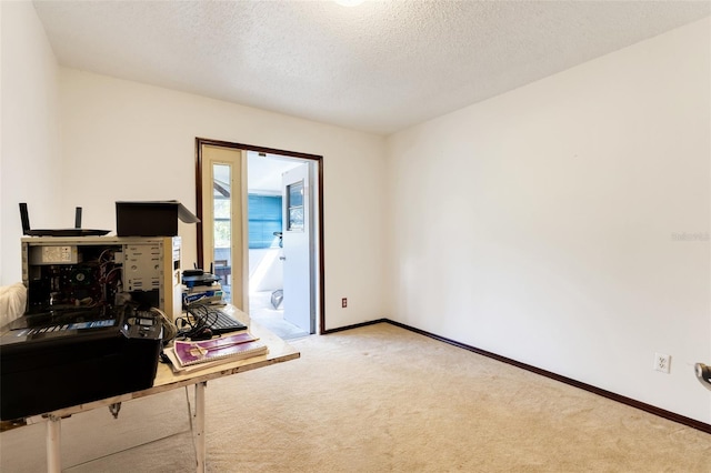 carpeted home office featuring baseboards and a textured ceiling