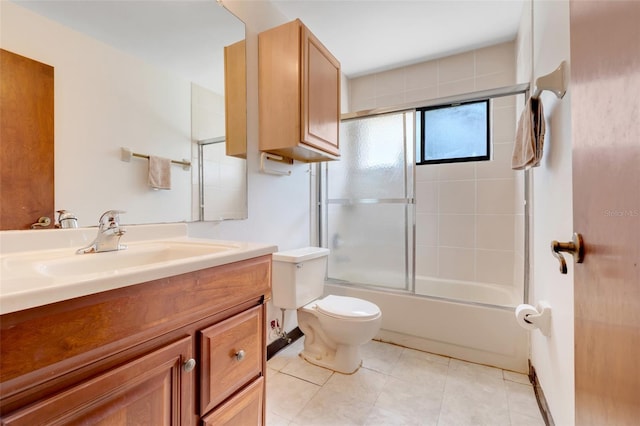 full bath featuring vanity, tile patterned floors, toilet, and bath / shower combo with glass door