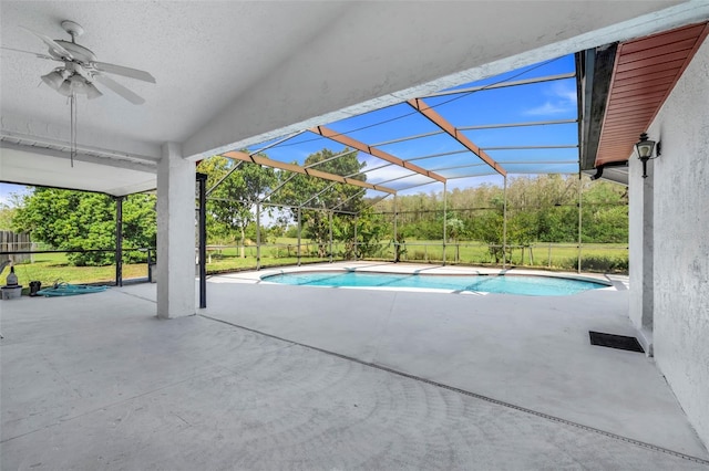 outdoor pool with a lanai, ceiling fan, and a patio