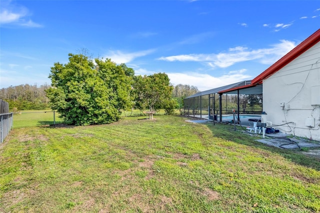 view of yard with an outdoor pool, glass enclosure, and fence