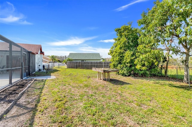 view of yard featuring glass enclosure and a fenced backyard