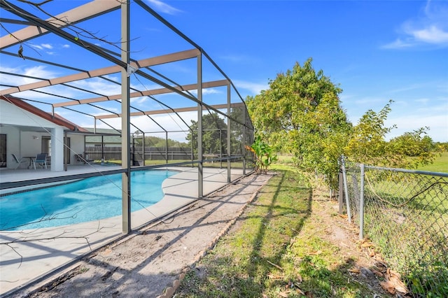 pool featuring glass enclosure, a patio, and fence