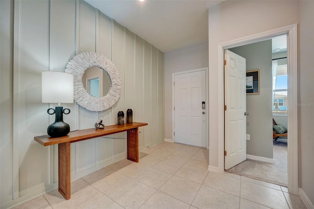 foyer entrance featuring light tile patterned floors and baseboards