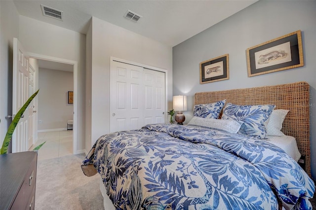 bedroom featuring light carpet, visible vents, baseboards, and a closet