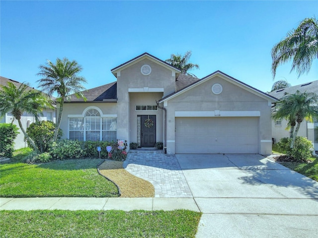 single story home featuring stucco siding, driveway, a front yard, a shingled roof, and a garage