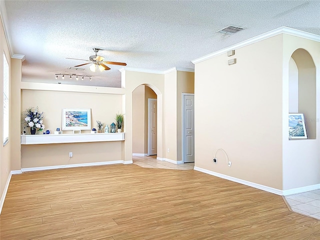 unfurnished living room featuring ceiling fan, visible vents, arched walkways, and wood finished floors