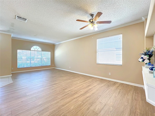 empty room with visible vents, crown molding, light wood-type flooring, and ceiling fan